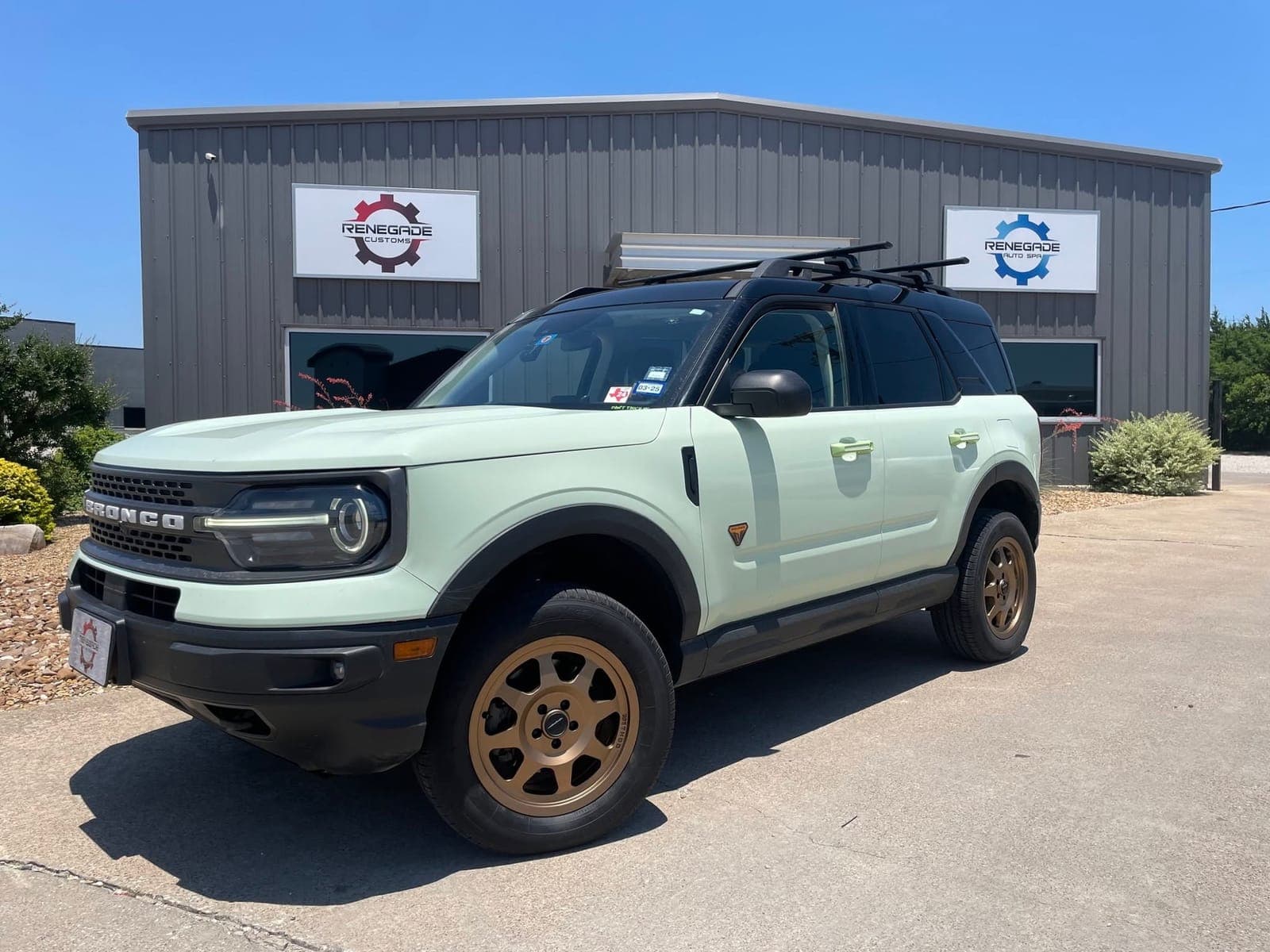 Lifted sage-green Ford Bronco Sport on bronze wheels at Renegade Customs