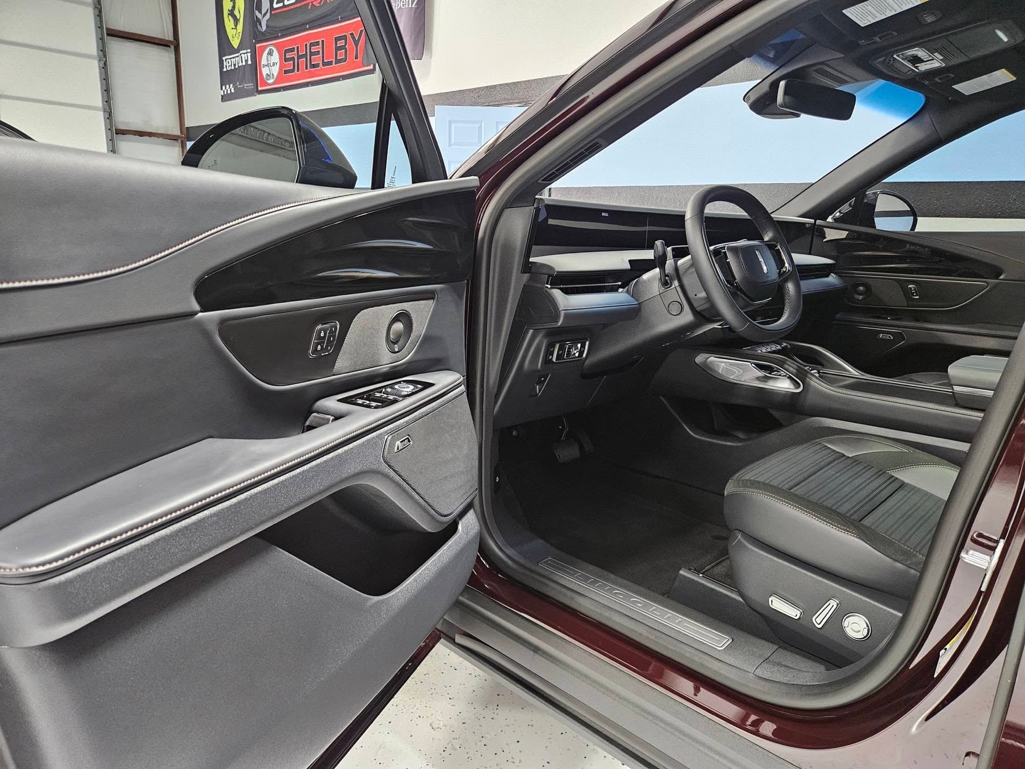 Detailed maroon Lincoln interior with the front door open at Renegade Auto Spa