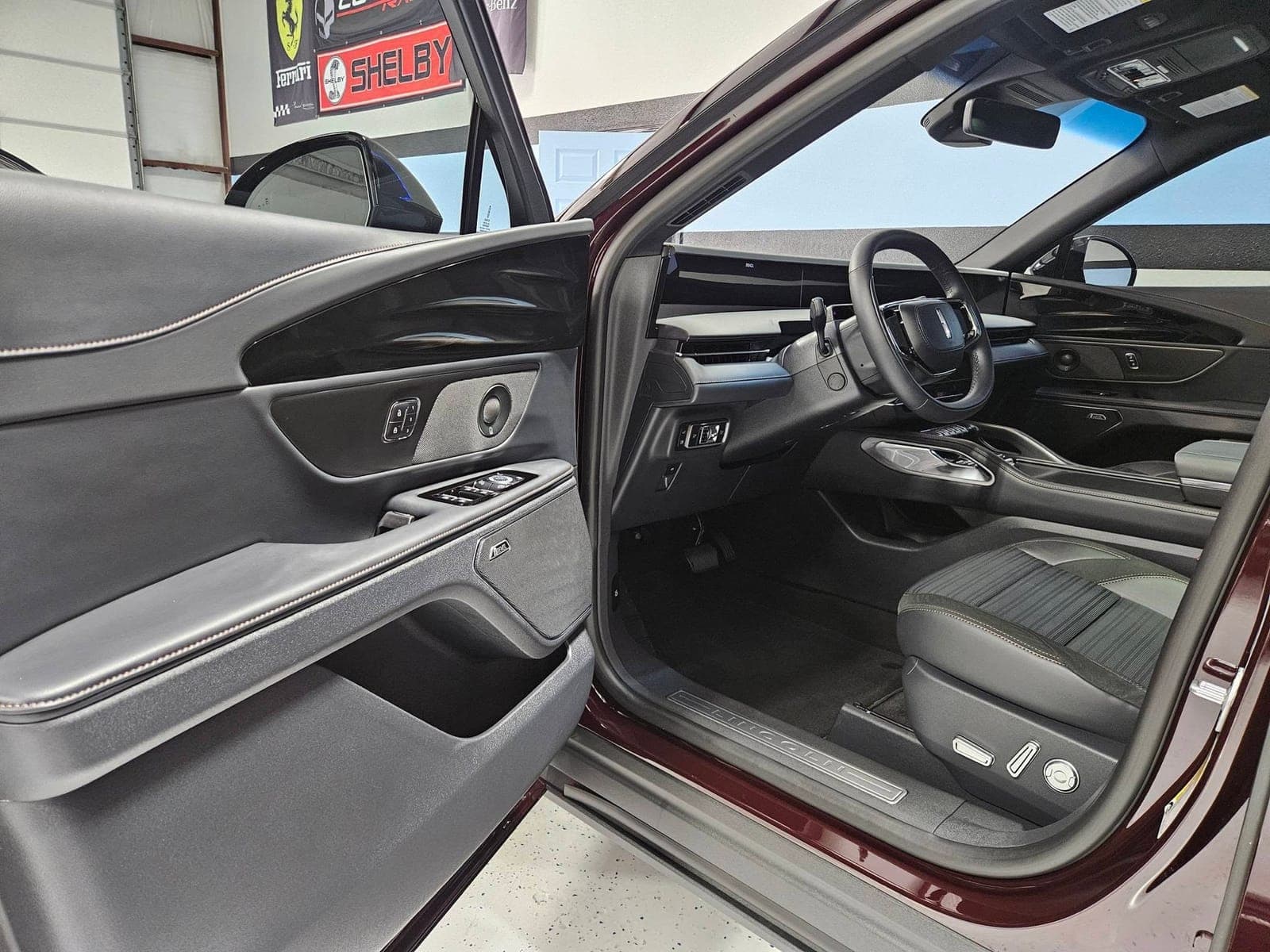 Detailed maroon Lincoln interior with the front door open at Renegade Auto Spa