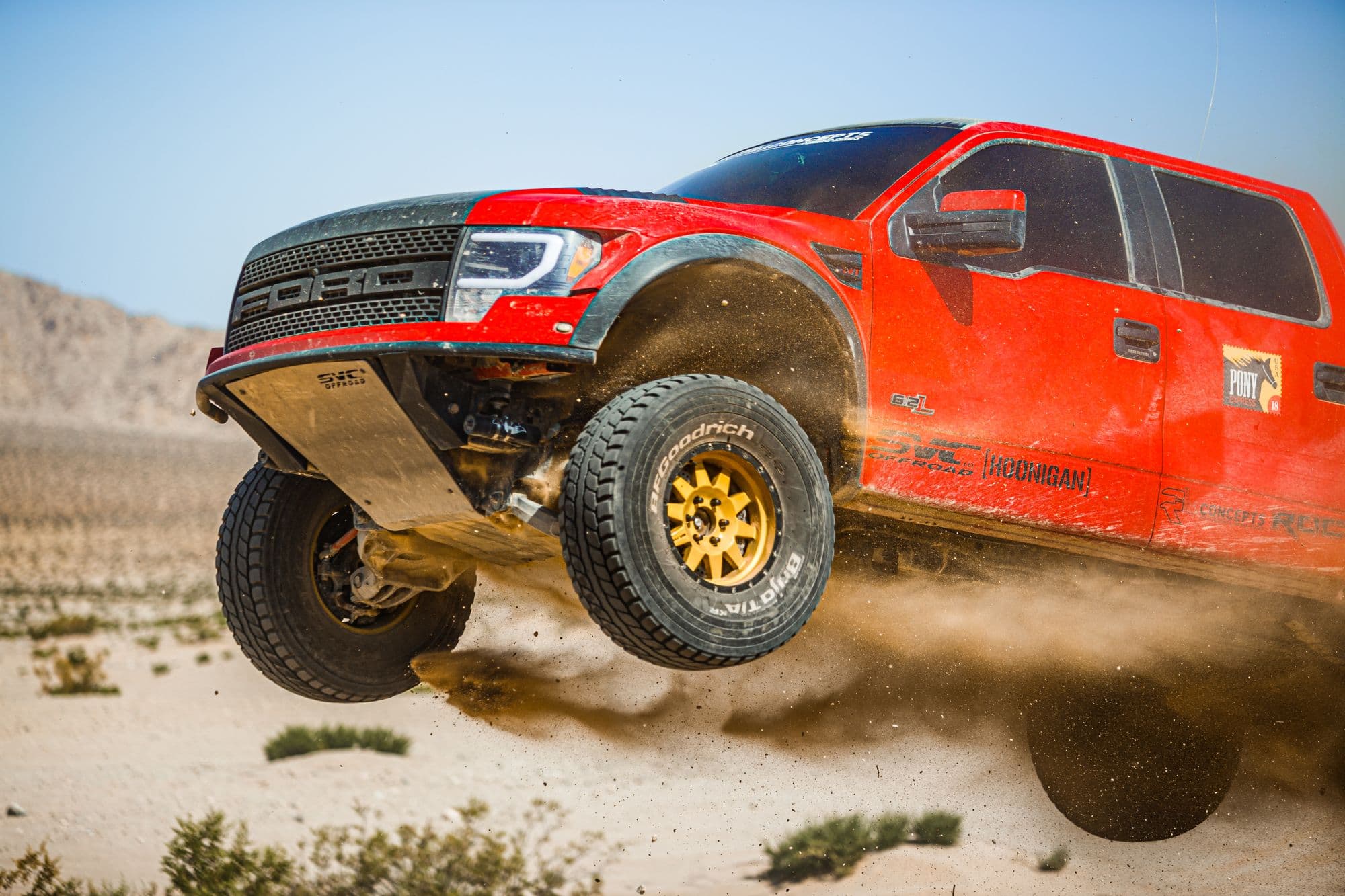Lifted truck catching air off-road on oversized tires